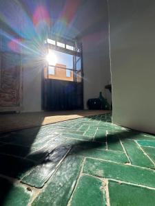 エッサウィラにあるLoft incroyable en médinaの窓のある緑の床の客室です。