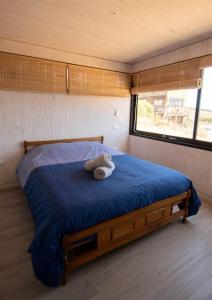 a bedroom with a bed with a teddy bear on it at Kinesurf cabaña con vista al mar in Pichilemu