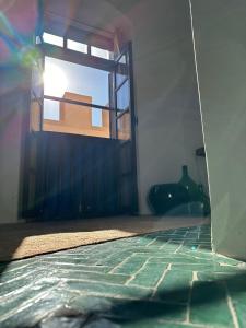 um quarto com uma janela e piso em azulejo em Loft incroyable en médina em Essaouira