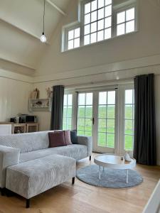 uma sala de estar com um sofá e uma mesa em Villa Nieuwland holiday home em Den Oever