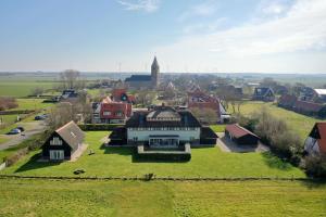 an aerial view of a large house in a village at Villa Nieuwland holiday home in Den Oever