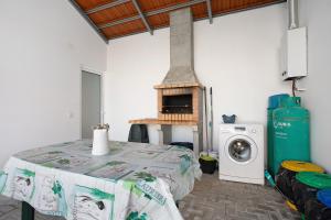 a room with a table with a stove and a washing machine at Casa Davó in Leiria