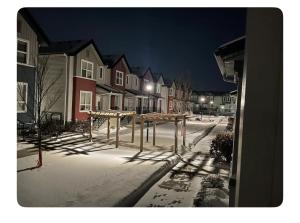 een met sneeuw bedekte straat 's nachts met huizen bij Edmonton in Edmonton
