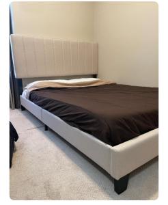 a bed with a white bed frame in a room at Edmonton in Edmonton