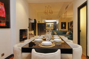 a dining room table with white chairs and a living room at Spanish Gold Edition in Rome