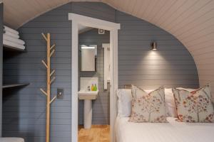 1 dormitorio con paredes azules y 1 cama con lavamanos en Long Ashes - Tan, en Tattenhall