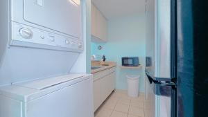 una cucina bianca con frigorifero e lavandino di Moana's Beach Apartment in Luquillo PR Beach View a Luquillo