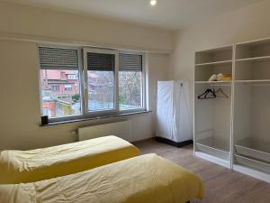 1 dormitorio con 2 camas y ventana grande en Spacious Apartment next to Port of Antwerp, en Amberes