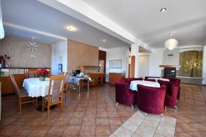 a restaurant with white tables and red chairs at Penzion Lesna in Vysoke Tatry - Tatranska Lesna