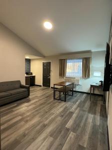 a living room with a couch and a table at Days Inn and Suites by Wyndham Port Huron in Port Huron