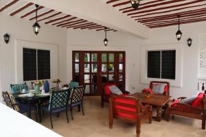uma sala de estar com mesa e cadeiras em Tahira Villa em Praia de Diani