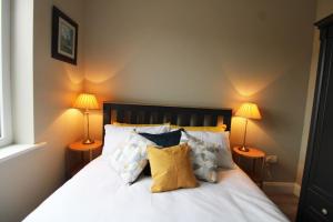 a bedroom with a bed with pillows and two lamps at Seagrass a luxurious gem by the sea in Youghal