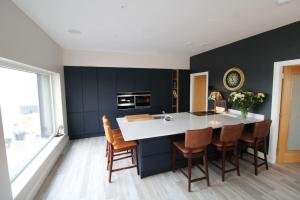 a kitchen with a white counter and a black wall at Seagrass a luxurious gem by the sea in Youghal