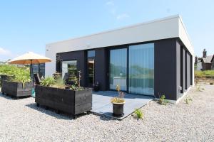 a black and white house with an umbrella and some plants at Seagrass a luxurious gem by the sea in Youghal