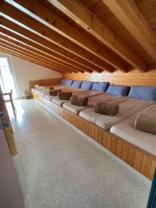 Cama grande en habitación con techo de madera en Touristenheim Bergfreude en Leukerbad