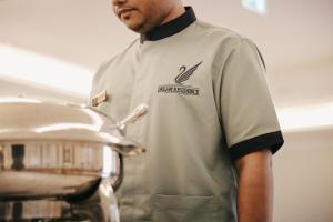 a man in a kitchen holding a pot at Dream Residence Rawabi-Serviced apartments in Al Khobar