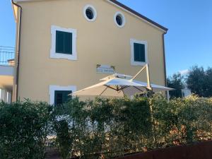 un bâtiment bien exposé avec un parasol devant lui dans l'établissement DON PEPPE ROOMS : Villaggio Green, à SantʼAngelo in Formis