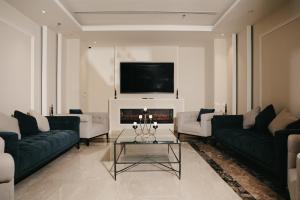 a living room with two couches and a fireplace at Dream Residence Rawabi-Serviced apartments in Al Khobar