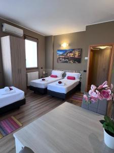 um quarto de hotel com duas camas e uma mesa em Bnbook-Tommaso Grossi Rho Fiera em Rho