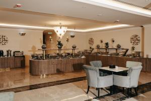 a restaurant with a bar with chairs and a table at Dream Residence Rawabi-Serviced apartments in Al Khobar