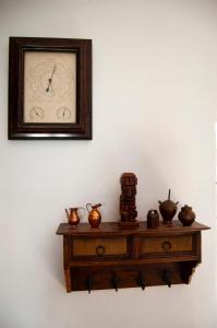 a clock on a wall above a wooden table at Casa en Villa Termal Las Caldas in Las Caldas