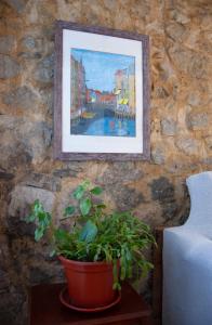 a painting hanging on a wall with a potted plant at Casa en Villa Termal Las Caldas in Las Caldas