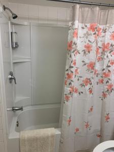 a bathroom with a shower curtain with pink flowers at Little Cute Home in Beverly Hills