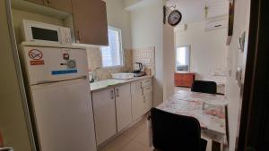 uma cozinha com um frigorífico branco e uma mesa em Apartments Petah Tiqwa - Bar Kochva Street em Petah Tiqwa