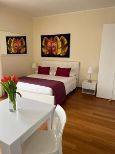 a hotel room with two beds and a table and chairs at Giardino Segreto in Peschiera del Garda