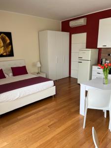a bedroom with a bed and a table and a kitchen at Giardino Segreto in Peschiera del Garda