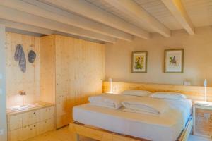 um quarto com uma cama num quarto com paredes de madeira em Agriturismo Locanda Case Vecie em Grezzana