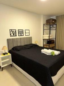 1 dormitorio con 1 cama grande con manta negra en Aconchego e Conforto no Centro de Teresópolis, en Teresópolis