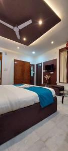 a bedroom with a large bed with a ceiling at The Kashi Inn - Near Assighat in Upal