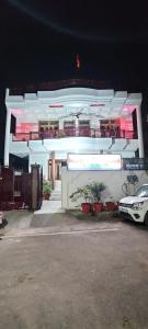 een wit gebouw met een auto ervoor geparkeerd bij The Kashi Inn. A 7 bedroom holiday home. Near Assi Ghat. in Upal