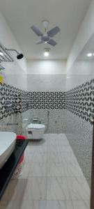 een badkamer met een toilet en een plafondventilator bij The Kashi Inn. A 7 bedroom holiday home. Near Assi Ghat. in Upal