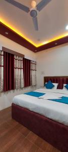 a bedroom with a large bed with blue pillows at The Kashi Inn - Near Assighat in Upal