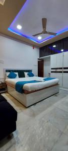 a bedroom with a large bed with a blue ceiling at The Kashi Inn - Near Assighat in Upal