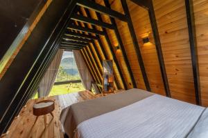 a bedroom with a bed and a large window at A Cabana mais aconchegante da Serra Catarinense in Urubici