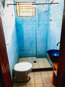 Baño de azulejos azules con aseo y lavamanos en Camping estrela Ubatuba, en Ubatuba