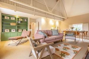 a living room with a pink couch and a table at Water Mill House 4 in Burnham Market