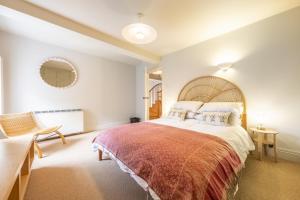 a large bedroom with a large bed and a chair at Water Mill House 4 in Burnham Market