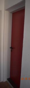 una puerta roja en la esquina de una habitación en Trogirsunset Apartments, en Trogir