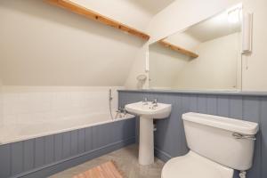 a bathroom with a toilet and a sink and a bath tub at Water Mill House 4 in Burnham Market +37 photos