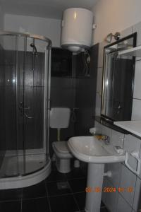 a bathroom with a shower and a sink and a toilet at Trogirsunset Apartments in Trogir