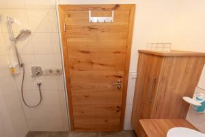 uma porta de madeira na casa de banho com um chuveiro em Apartment Drautalblick em Oberdrauburg