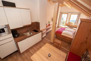 una cocina con armarios blancos y una cama en una habitación en Apartment Gailtalblick, en Oberdrauburg