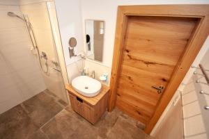 baño con lavabo y puerta de madera en Apartment Gailtalblick, en Oberdrauburg