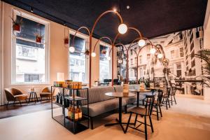 a restaurant with a couch and tables and chairs at Anne&Max Boutique Hotel in Utrecht