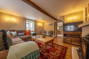 a living room with a couch and a tv at York Cottage in Thornham