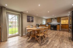 a kitchen and dining room with a wooden table and chairs at York Cottage in Thornham